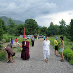 Mindful walking up the driveway toward the tent; people stretching and practicing Qi Gong