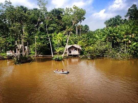 Lots of huts and women and children in boats along the river.