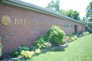 A sunny photo of the Brewer Library contrasts with the tale of a dark book