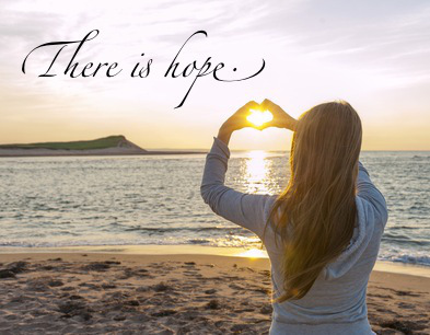 Girl holding hands in heart shape at beach