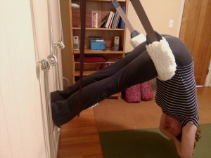 photo of down dog yoga pose variation, hanging from yoga swing.