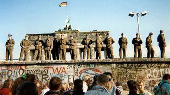 East German border guards stand on a section of the Berlin wall with the Brandenburg gate in the background on November 11, 1989 in Berlin. (AFP Photo / Gunther Kern)