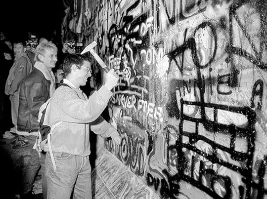 A man hammers a section of the Berlin Wall near the Brandenburg Gate after the border opening was announced, November 9, 1989. (Reuters / Fabrizio Bensch)