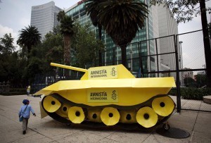 A child walks around a fake tank parked outside the U.S. embassy during a protest held by Amnesty International in Mexico City