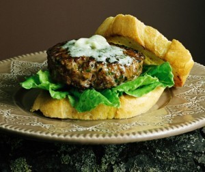 A lamb burger on baguette and lettuce leaves