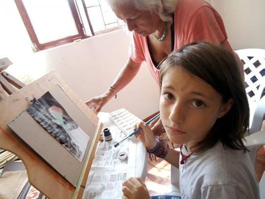 A young person painting with another person