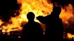 Silhouettes in front of a world on fire