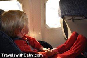 Baby or toddler flying on airplane in red christmas PJs