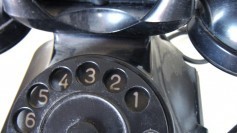 A very old telephone (landline, handset, rotary dial)