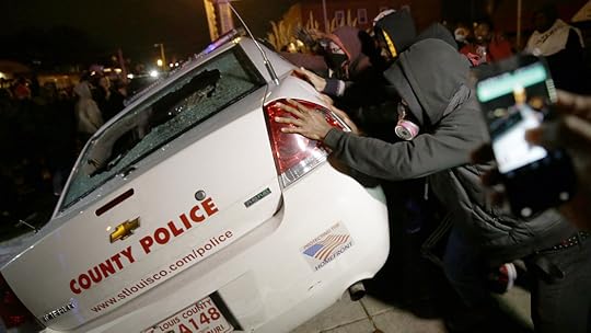 Protestors in Ferguson attempt to overturn police car (David Goldman/AP photo)
