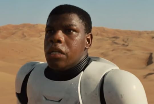 John Boyega's character wearing a stormtrooper uniform looking confused and afraid in the desert