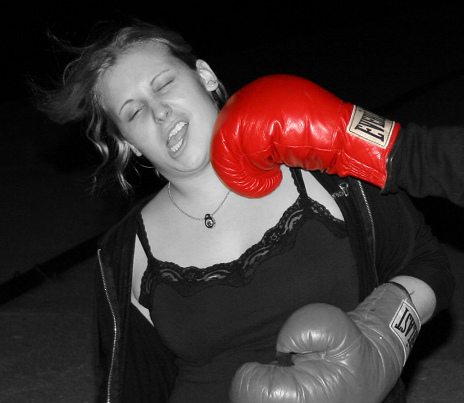 Girl getting knocked out by boxing glove.