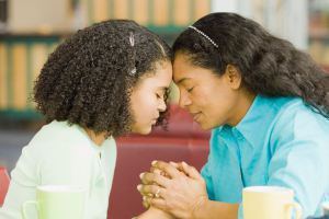 Mother-and-daughter-praying-in-coffee-shop