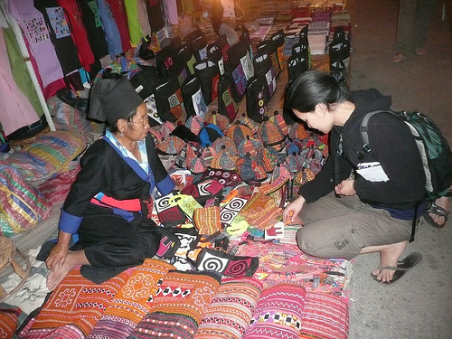 A fabric vendor and traveler at a market in Luang Prabang, Laos.