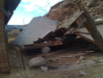 A small barn destroyed by the 2010 rockfall and the equally small boulders that did the job. My unharmed horse barn to the left.