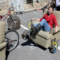 Kaylin Broussard is seen here showing off her and fiance Chris Bartlett's work on a rather unique recumbent tricycle. Also seen in the background is a bike with what look like the most dangerous wheels I've ever seen.