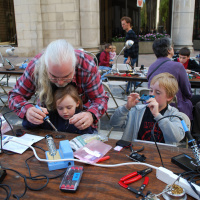 Sam Thompson teaches his young 'uns to solder at the first RI Mini Maker Faire