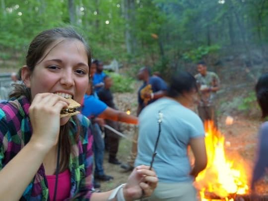 Girl eating at campfire