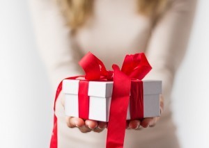 Woman holding white present box with red ribbon