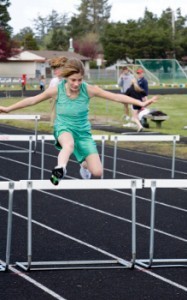 Photo of a girl jumping over hurdle