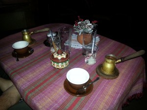 Coffee service with djzhezve, cups, and spoonfulls of byalo sladko in water 