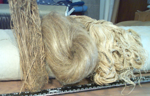 On the left are flax stalks, center are flax fibers, and right is the resulting thread after it has been spun many times.