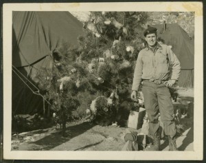 Nicholas W. Phillips in front of Christmas tree decorated with beer cans.