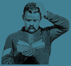 Man scratching his head while reading a book