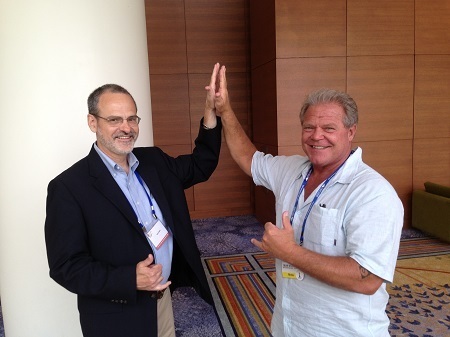 Catholic speaker Gary Zimak giving a high five to his friend and fellow evangelist Bear Woznick