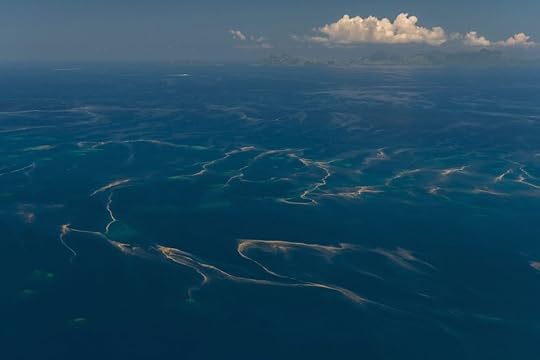 Aerial - of scattered small reefs with very possible coral spawn on the water's surface.