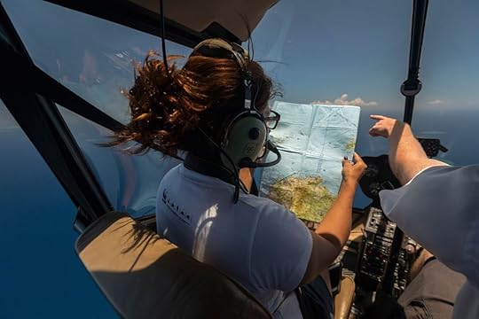 atricia Mallam of WWF South Pacific, aloft in a Robinson 44 helicopter, checks a map so she can locate the Yasawa reef, a popular spot for divers. Photo: Jürgen Freund