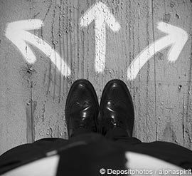 Business Man Standing in Front of Arrows
