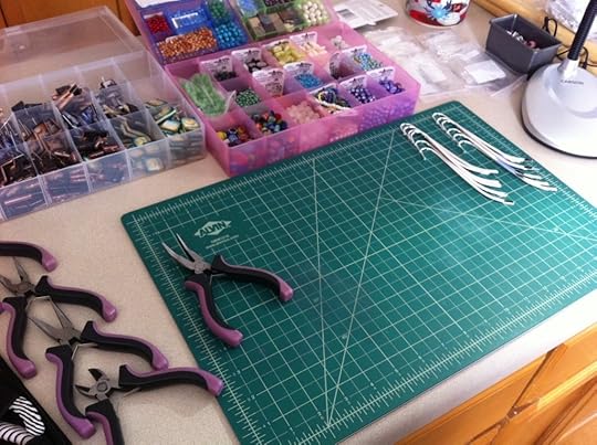 Work surface, ready to make book charm bookmarks. Note the coffee cup peeking out at the top right. Yeah, I needed that.