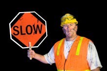 Dirty construction worker holding slow sign