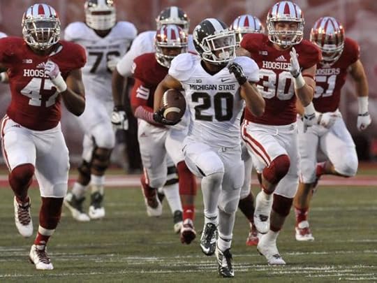 Michigan State running back Nick Hill does a tightrope act along the sideline and leaves Indiana's T.J. Simmons behind at Memorial Stadium in Bloomington, Ind., on Saturday, Oct 18, 2014. The Spartans defeated the Hoosiers, 56-17. Dale G. Young, Detroit News