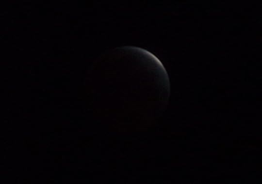 Silver and reddish brown moon at the cusp of a total eclipse 