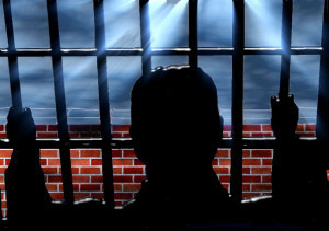 silhouette of a person behind bars