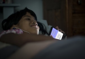 Young patron reads at bedtime using her smartphone.