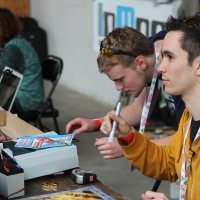 YouTube creator Experiment Boy signs posters for his fans while showing off his builds at the Maker Faire in Saint Malo.