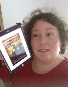 Ronda Del Boccio holding the Kindle edition of Black Cloud Rising: CHrytsalis by Darrel Sparkman, showing the cover