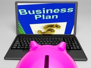 A piggy bank looking at a laptop with a business plan on the screen