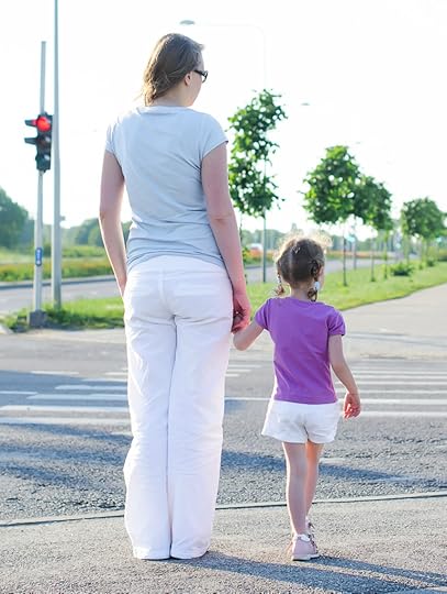 Mother and child crossing the road. Back view.