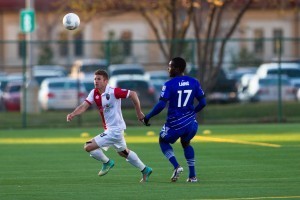 FCE's Lance Laing follows the ball as Ottawa defender Brandon Poltronieri dashes for it.