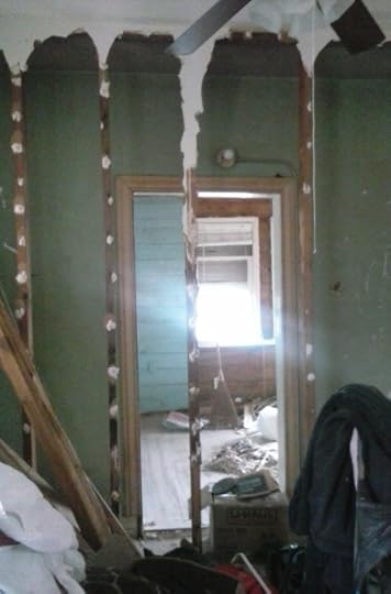 Bedroom door revealed when makeshift closet is removed in dining area.