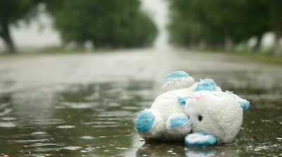 stock-footage-lost-toy-in-a-puddle-under-rain-surface-level