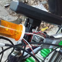 The PSoC 4 BLE module encased inside a pill container, mounted to the handlebars.
