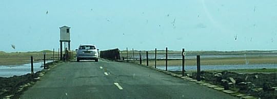 The causeway to Holy Island. The causeway can only be used at low tide, and the poles at the side of the road show where the high tide reaches, to indicate when it is unsafe to cross.