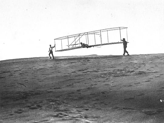 Orville being launched for an early flight in 1902. Brother Wilber and a friend are at each wingtip.