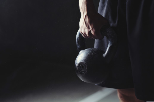 Close-up of a muscular hand holding a kettlebell