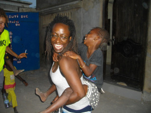 laughing Jamillah carrying child on back